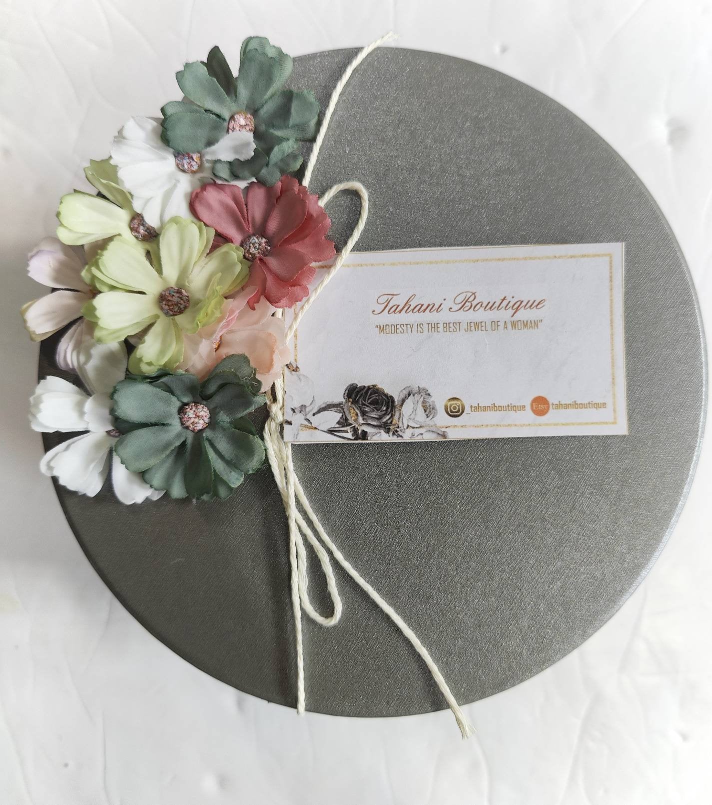 A wrapped Tahani Boutique gift box with a branded tag, tied with twine