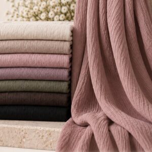 Crinkle cotton hijabs folded in a stack with one draped alongside, showing the textured crinkle finish